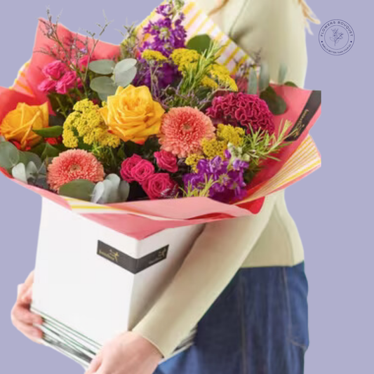 Colorful bouquet with yellow roses, pink carnations, chrysanthemums, and eucalyptus, presented in a premium white gift box.