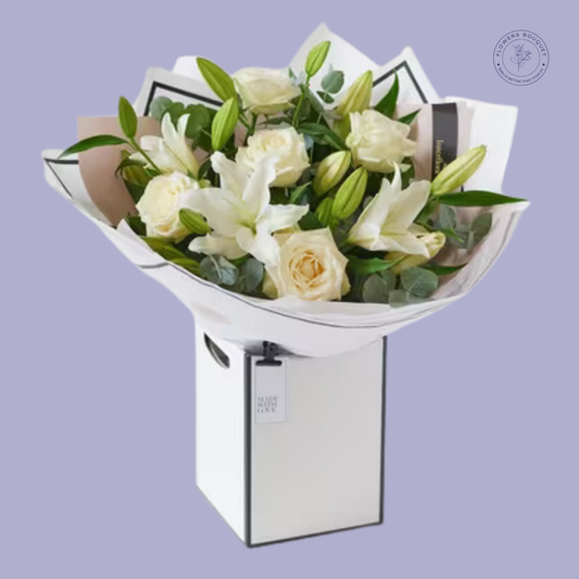  Elegant white rose and lily bouquet in a premium white gift box, with eucalyptus leaves for a fresh green touch.