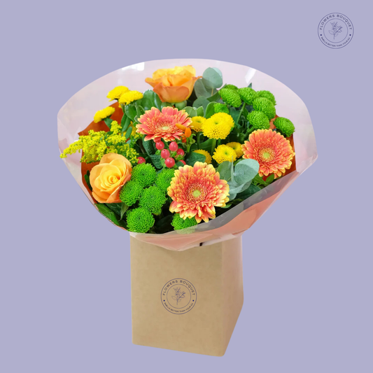 Golden Harvest Bouquet featuring orange roses, golden gerbera daisies, yellow and green chrysanthemums, hypericum berries, and eucalyptus in a kraft gift box.